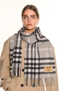 A diverse flat-lay featuring Scottish tartans and Irish-inspired emerald cashmere stoles, prepared for global festival gifting.