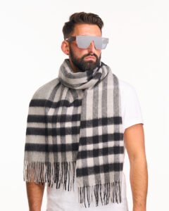 A folded light grey cashmere scarf in a signature luxury box.
