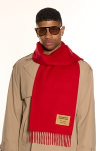A folded red cashmere scarf in a luxury signature box.