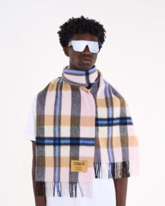 A male model wearing a beige cashmere scarf outdoors.