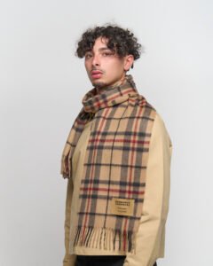 A stylised artistic arrangement of red and gold thistles surrounding a Thomson Red cashmere scarf.
